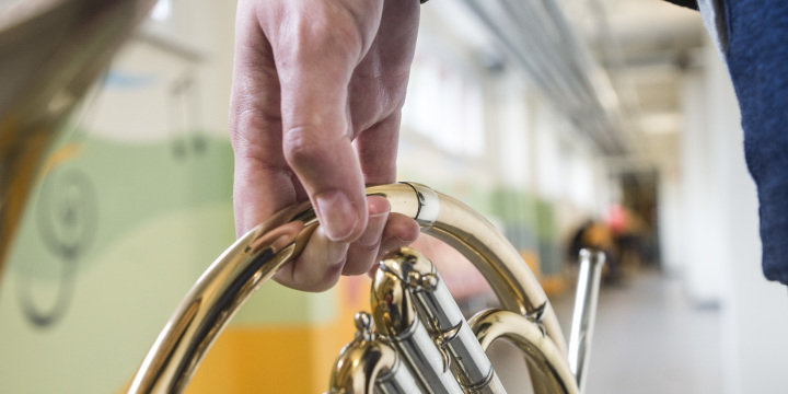 Person läuft mit Horn in der Hand im Kellergang der Musik- und Kunstschule Jena  ©A. Hub